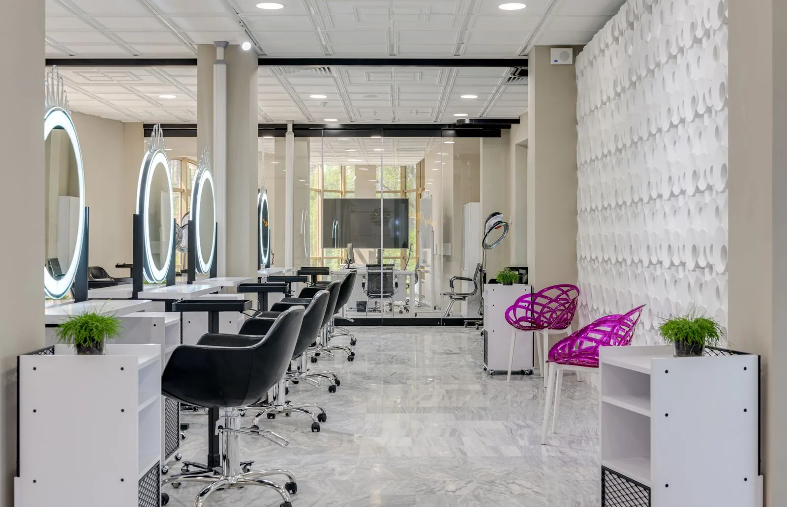 A hair salon with styling chairs and illuminated mirrors