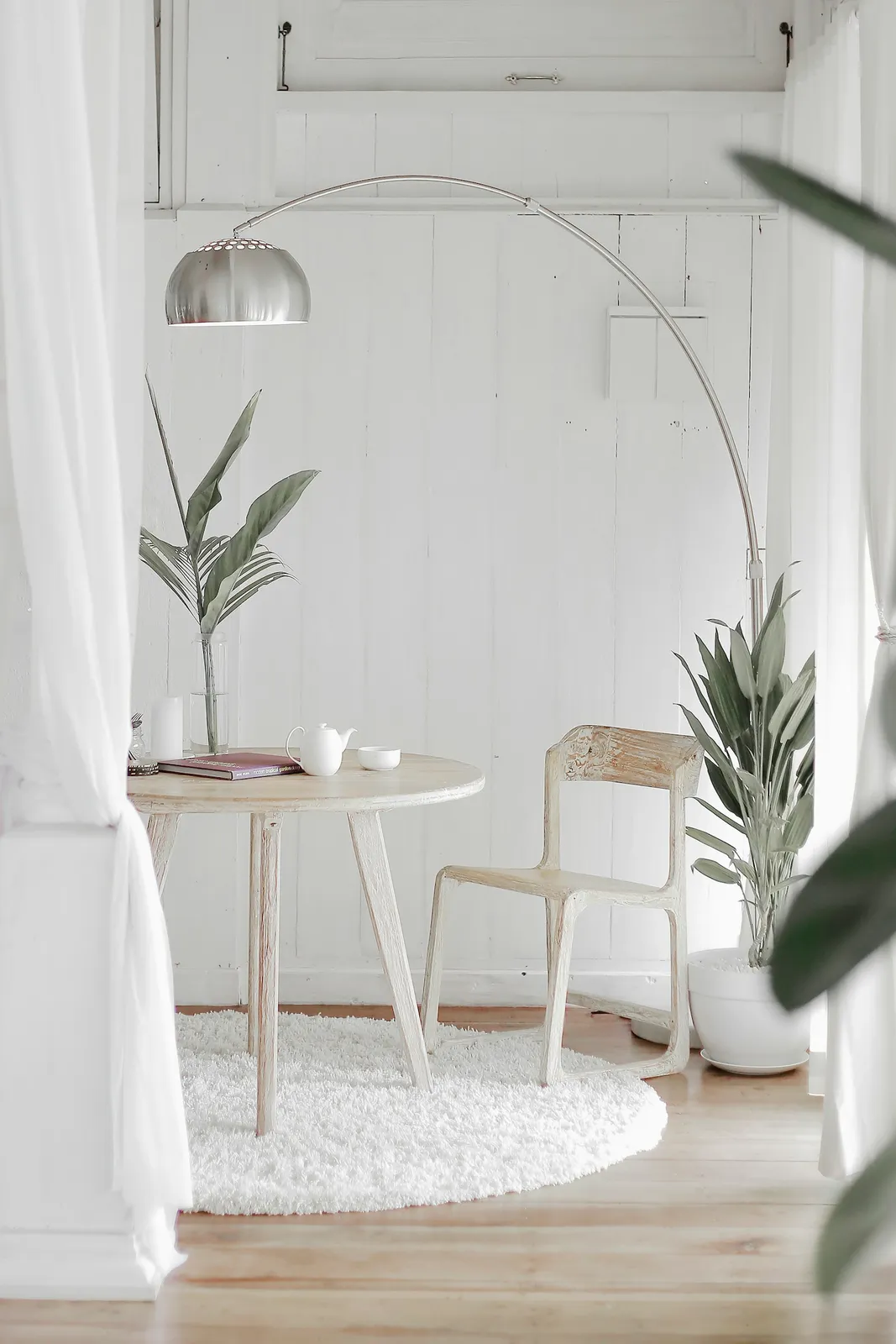 White steel chair in front round table on white rug