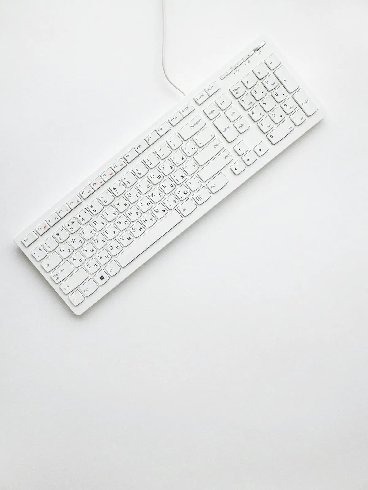 White corded computer keyboard on white surface