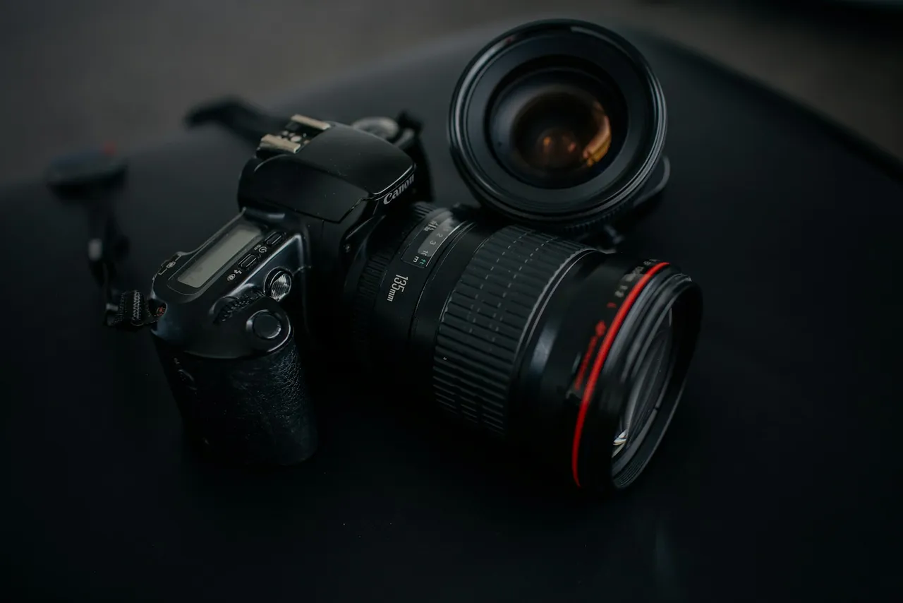 Black Canon DSLR camera beside camera lens