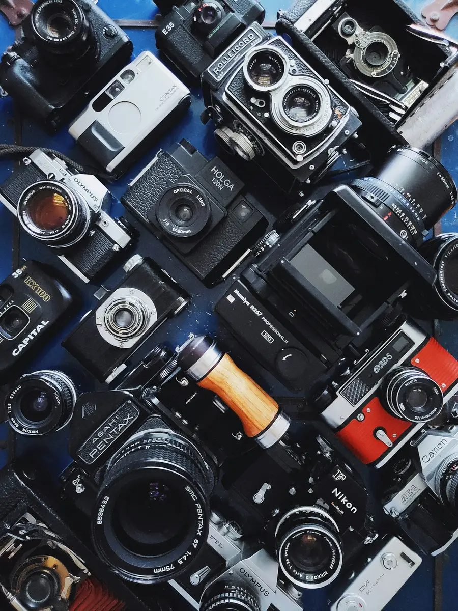A table topped with lots of different types of cameras