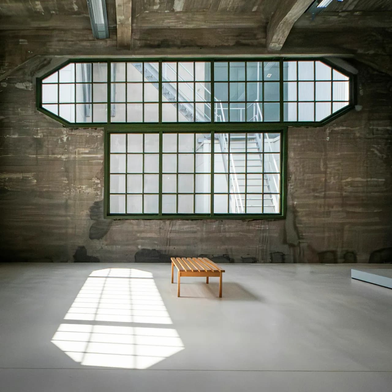 Empty room with large windows and wooden bench
