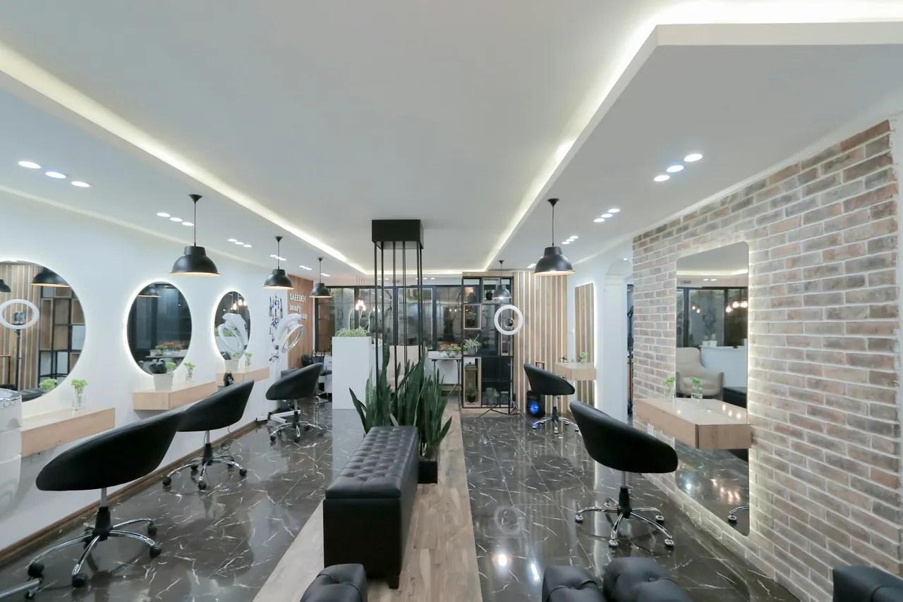 A modern hair salon with black chairs, round mirrors, and a brick wall